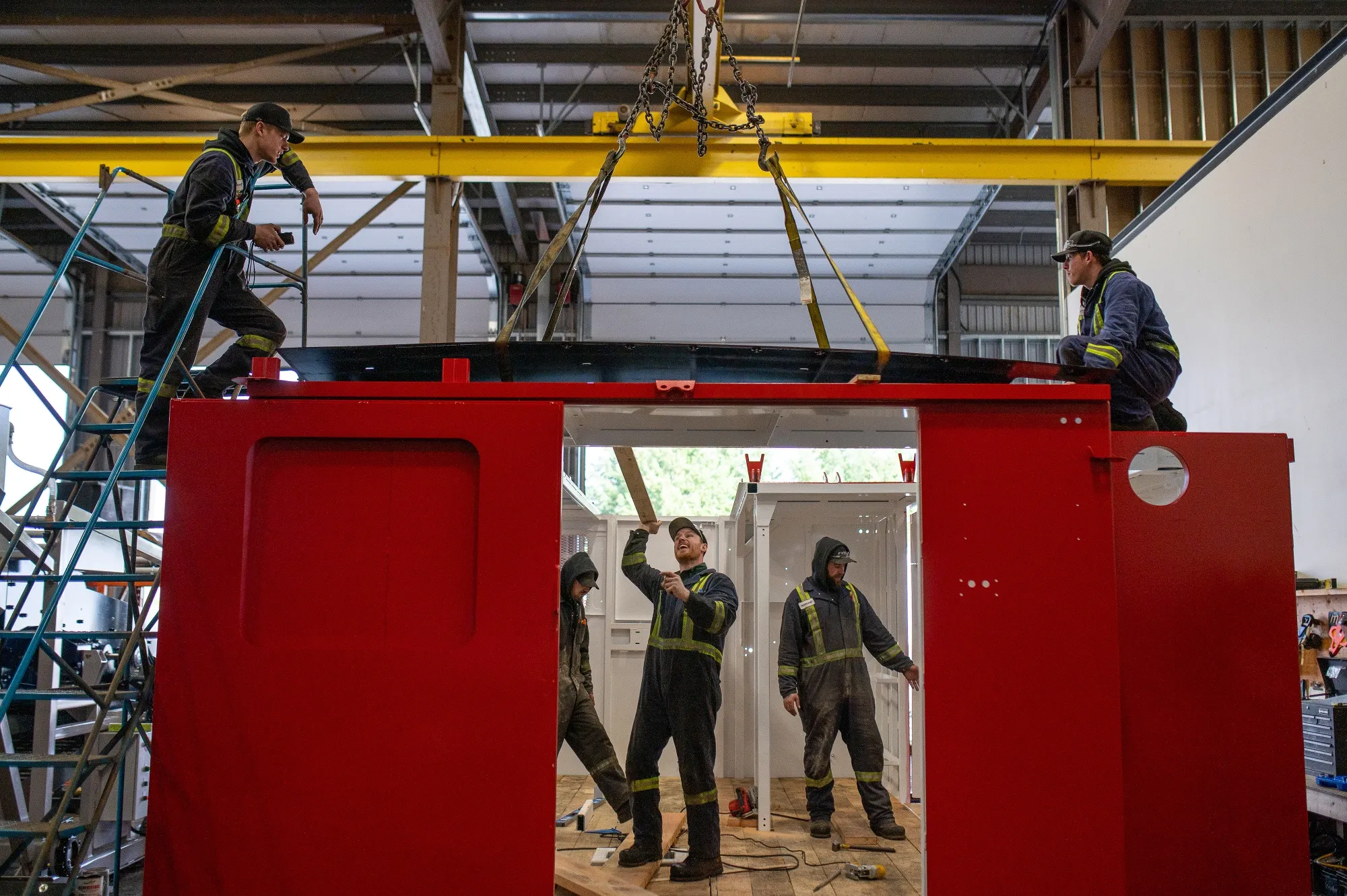 Workers assemble a heavy duty drill shack at a mining equipment manufacturing shop in Parksville, British Columbia.