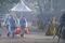 Volunteers wearing protective suits distribute food to the