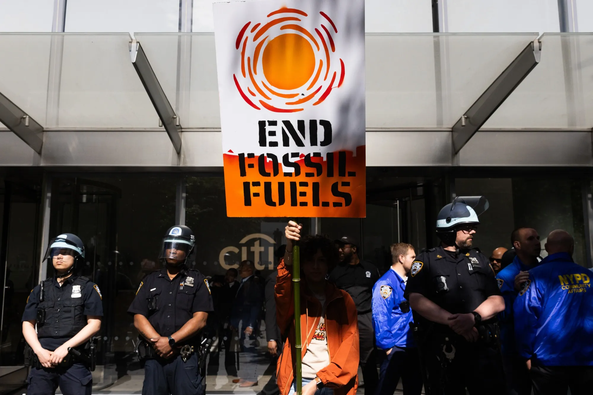 A climate activist holds a sign during a protest outside Citigroup headquarters on June 2024.