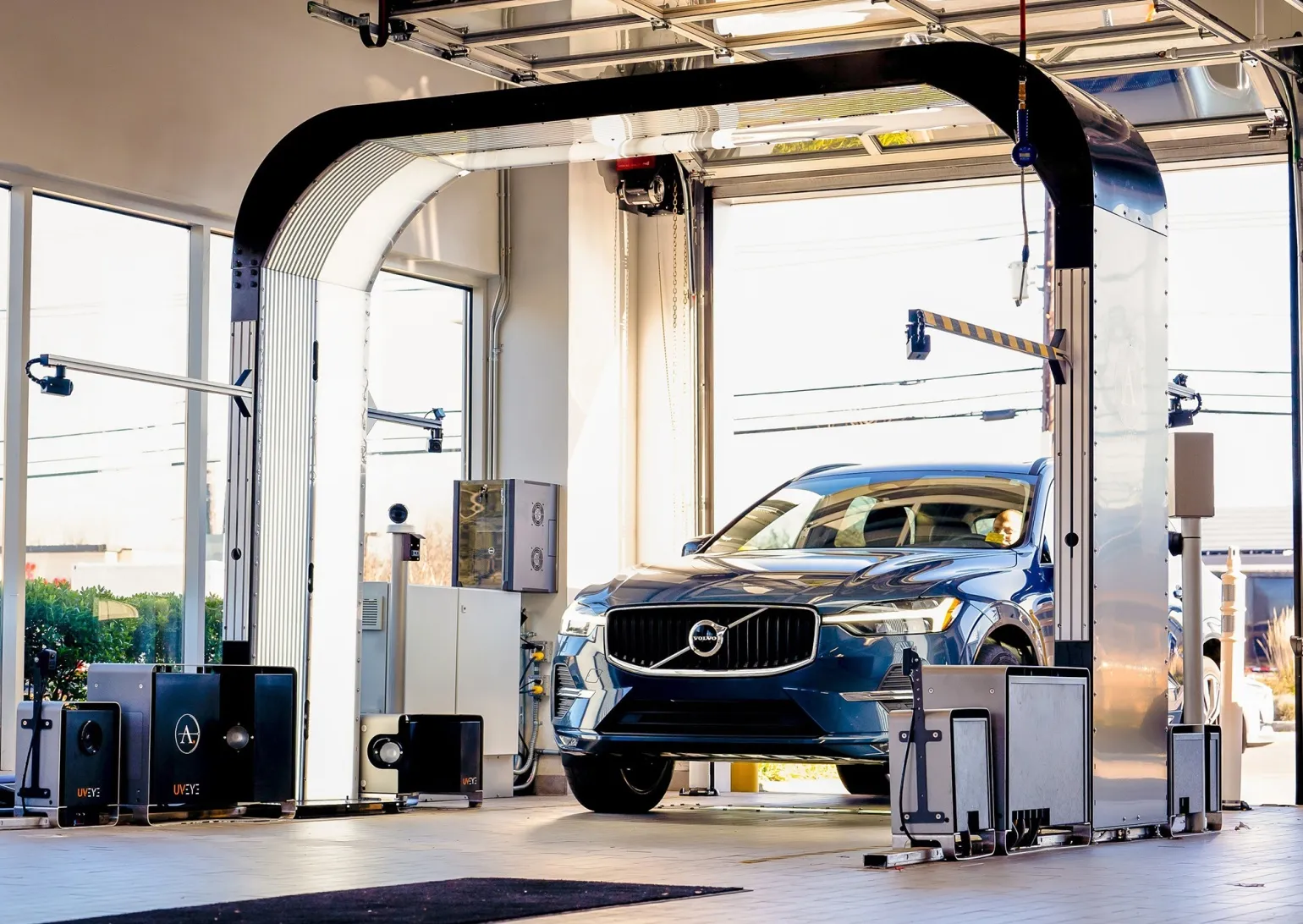 UVeye high-speed inspection systems on a dealership service lane check a car’s tires, underbody and exterior components.