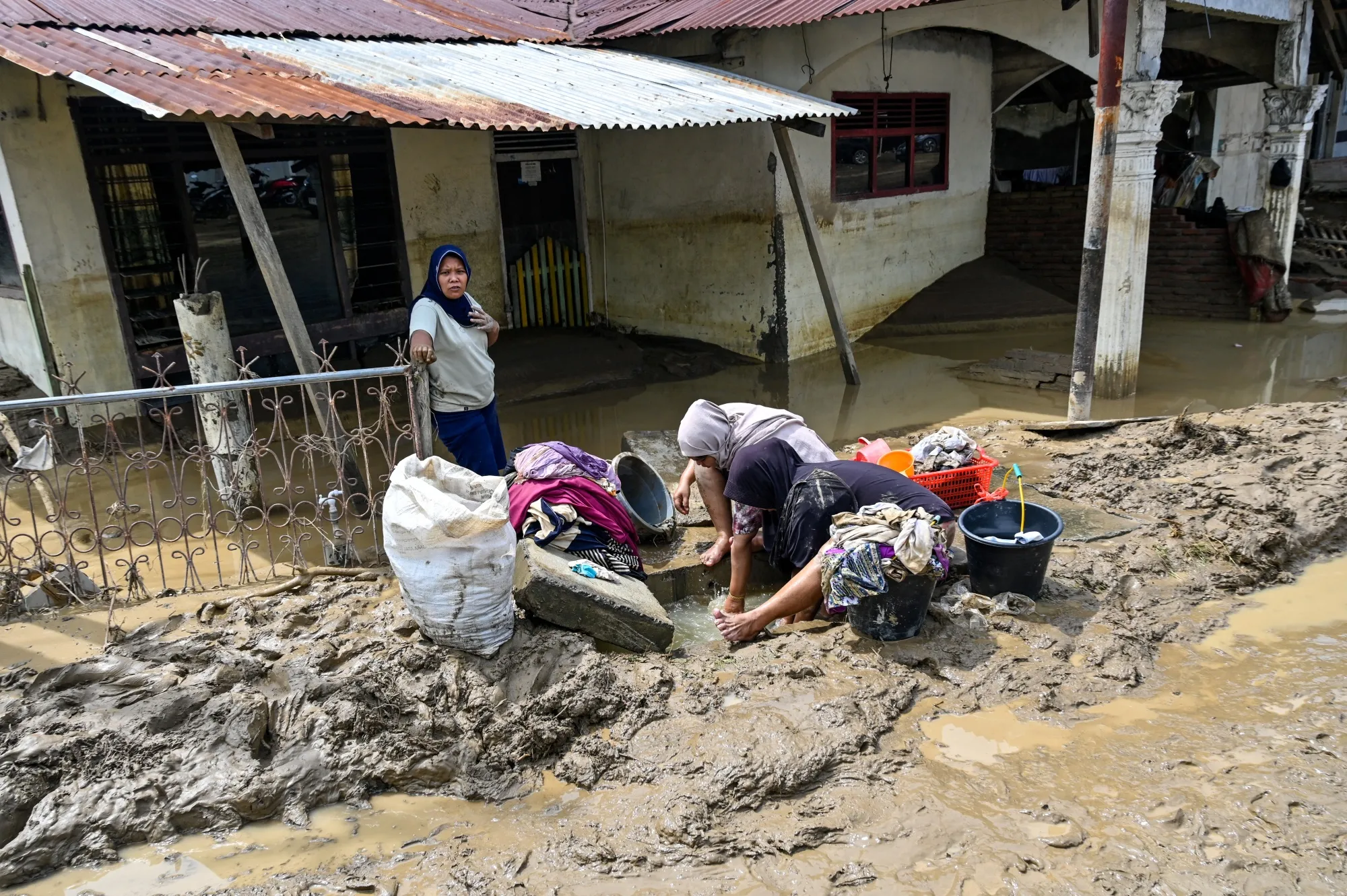 Women clean their belongings after the flash floods in&nbsp;Aceh province, on Nov. 28.
