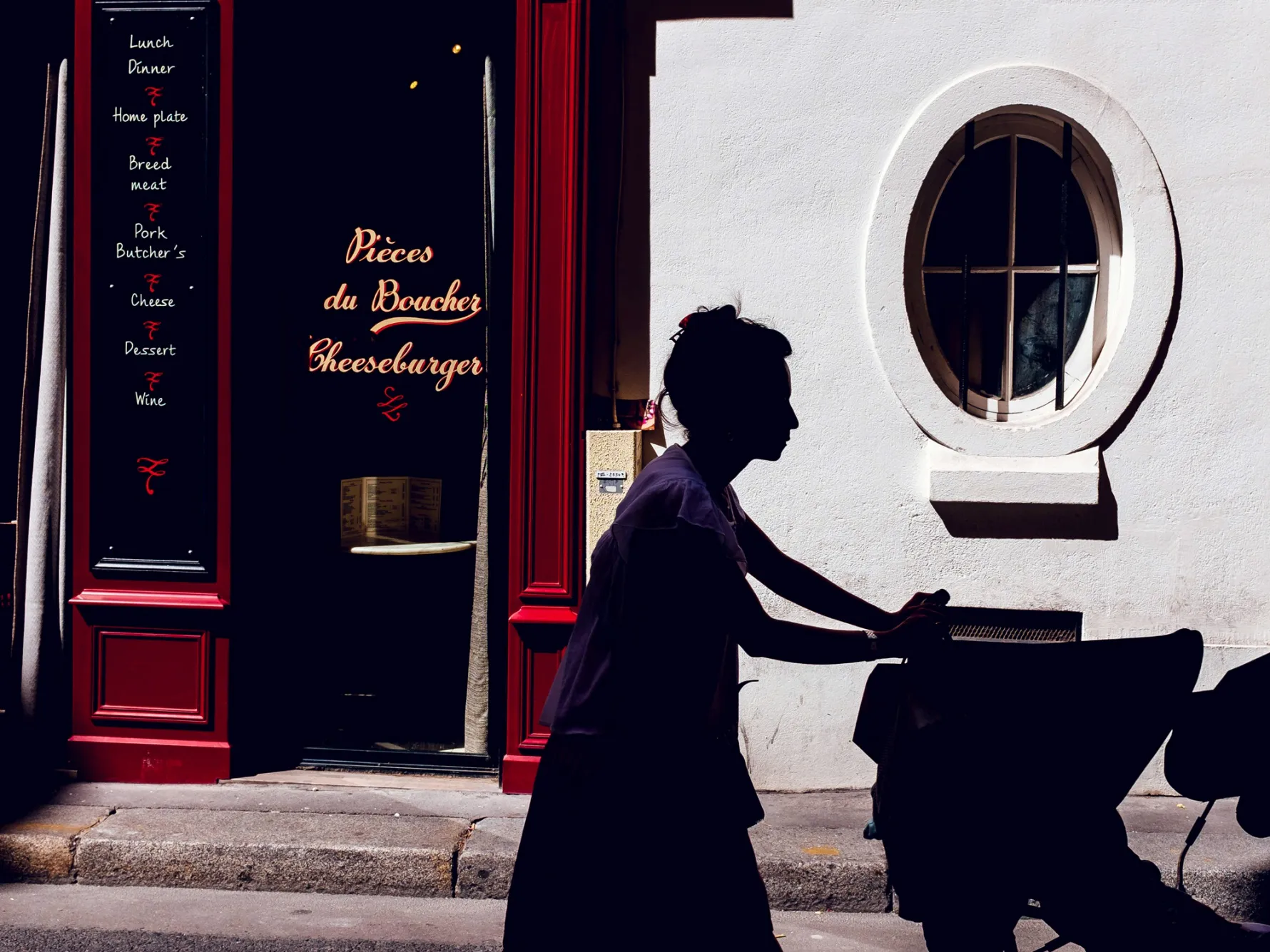 Young girl pushing baby carriage and walking down a street