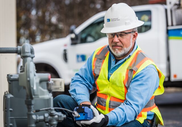 
A Piedmont Natural Gas technician uses a combustible gas indicator on a meter set at a commercial building in Greenville, South Carolina in December 2021. 