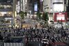 Pedestrians cross an intersection at night in the Shibuya district of Tokyo, Japan, on Friday, July 10, 2020. Japan is forging ahead with further steps to re-open the economy even as daily coronavirus cases continue to climb, with local media reporting Tokyo posting a daily record of over 240 infections on Friday.