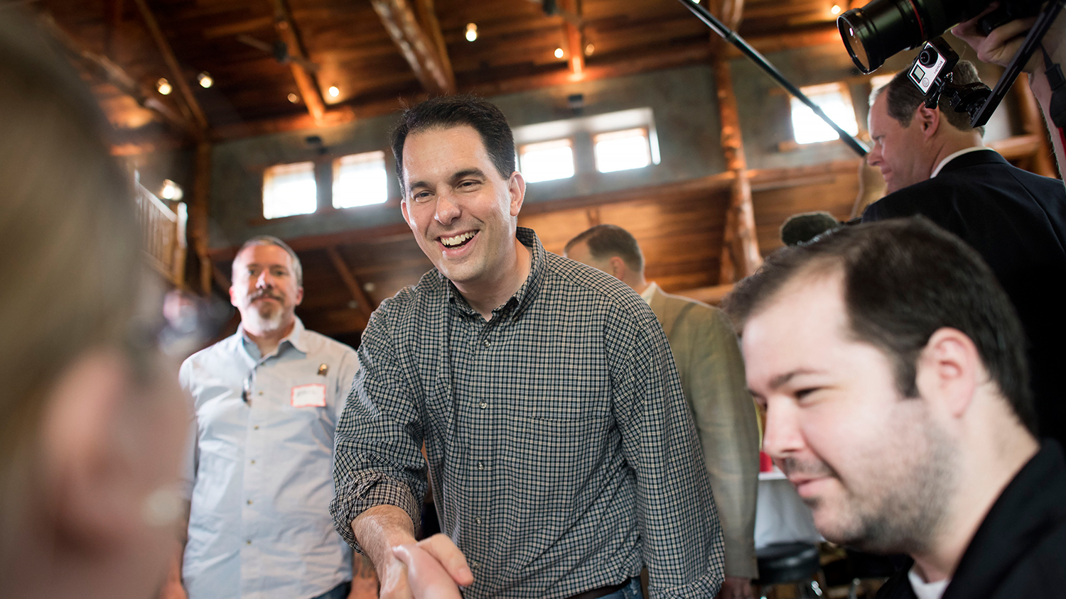 Scott Walker, governor of Wisconsin, greets an attendee during the Chad Airhart Blue Jean Bash fundraiser in West Des Moines, Iowa, U.S., on Saturday, May 16, 2015.
