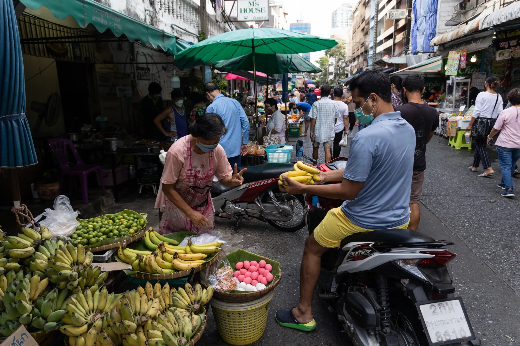 A customer buys fruits at Silom Market on Silom Road in Bangkok, Thailand.
