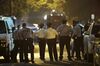 Policer officers watch as a gunman is apprehended following a standoff in Philadelphia.