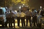 Policer officers watch as a gunman is apprehended following a standoff in Philadelphia.