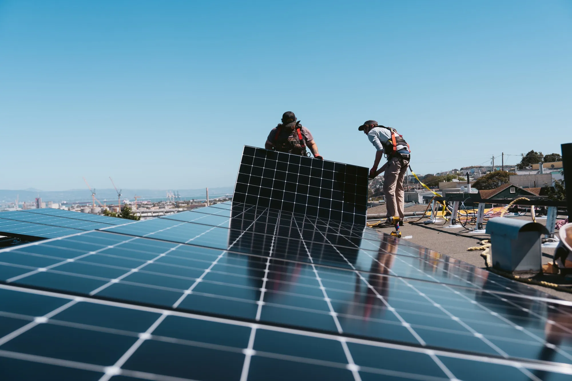 Workers install solar panels at a home in San Francisco.