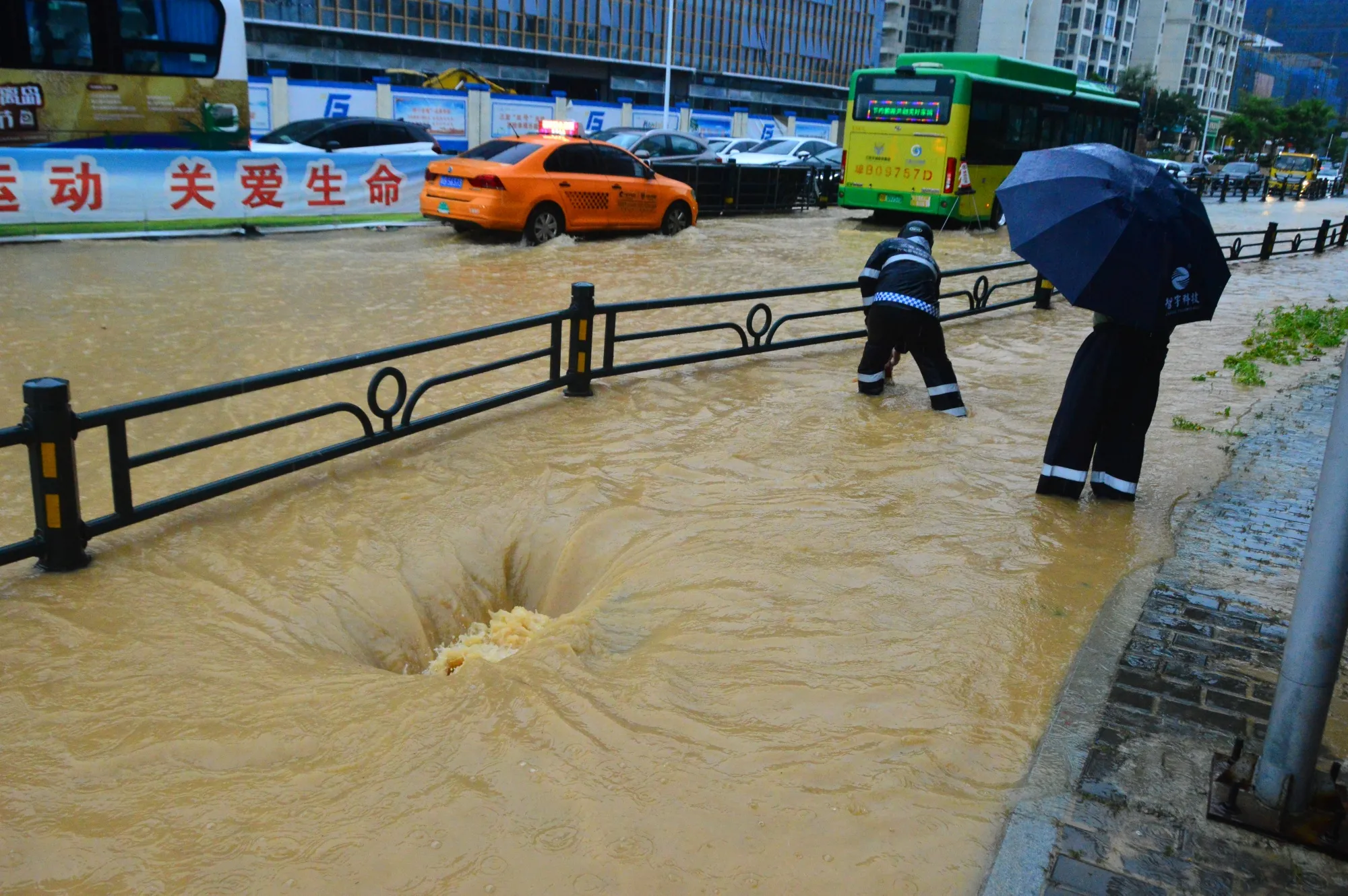 Flood water flows in to a manhole during heavy rains in Sanya, Hainan Province on July 2.