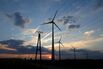 Wind Turbines And Electricity Cables Against A Dramatic Sky