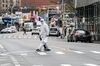 A man wearing a protective suit walks outside NewYork-Presbyterian Queens Hospital in the Queens borough of New York.