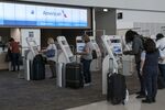 Travelers&nbsp;use check-in kiosks at an American Airlines counter.