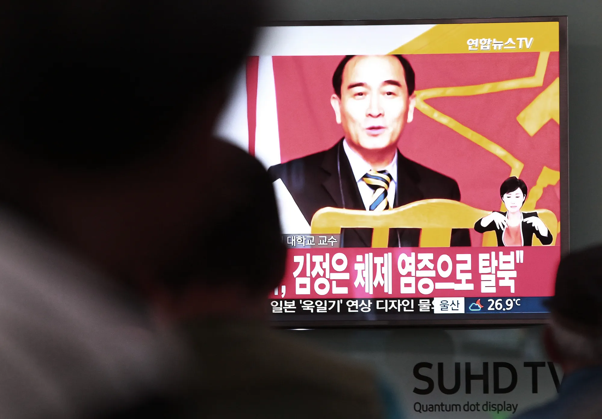 People watch a TV news showing Thae Yong Ho on Aug. 17.
