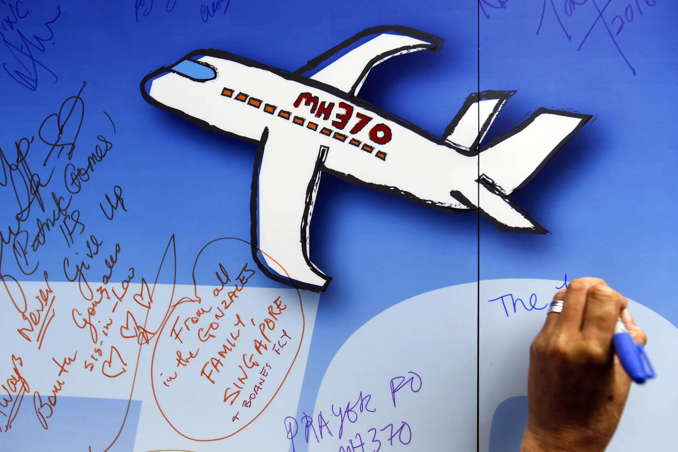 A Malaysian writes well wishes on a wall of hope during a remembrance event for the ill fated Malaysia Airlines Flight 370 in Kuala Lumpur, Malaysia, Sunday, March 6, 2016. At the commemorative event Sunday to mark the second anniversary of the jet’s March 8, 2014, disappearance, the families of Flight 370 passengers released white balloons tagged with the names of everyone aboard the plane and the words: “MH370: Always remembered in our hearts.”
