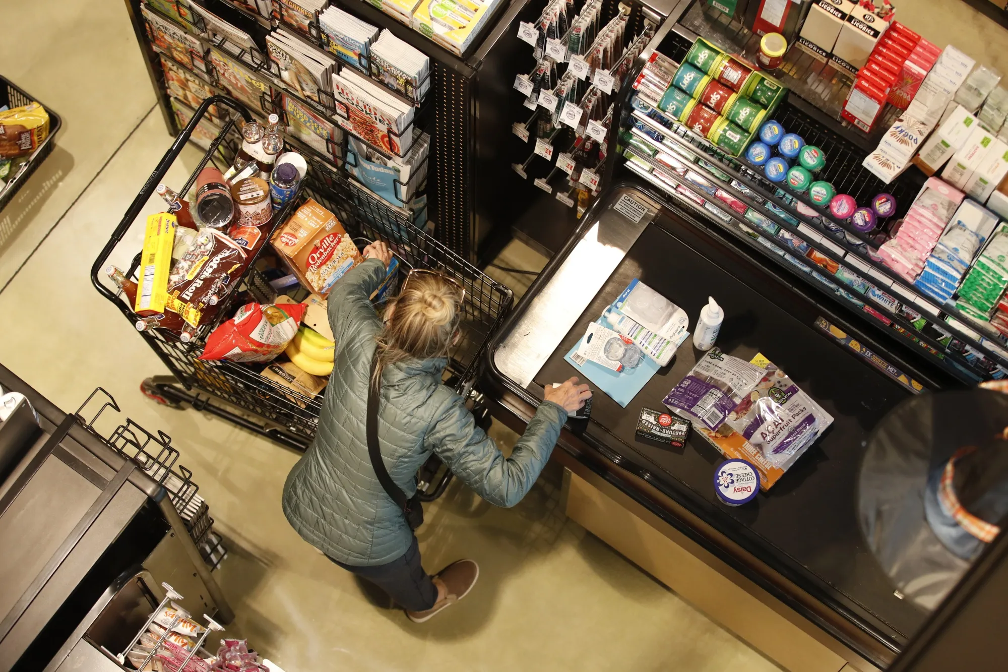 A customer places items on a conveyor belt at a checkout counter&nbsp;in Salt Lake City.