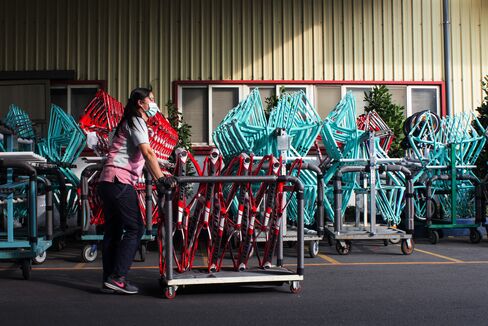 An employee pushes a rack of bicycle frames at the Giant Bicycle factory in Taichung.