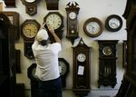 A worker&nbsp;adjusts the time at a clock shop in Plantation, Florida.&nbsp;
