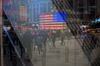 Pedestrians are reflected in a window of the Nasdaq MarketSite in the Times Square neighborhood of New York, U.S., on Monday, April 8, 2019. U.S. stocks pared losses as investors awaited signs of progress in the trade war with China ahead of the latest corporate earnings season.
