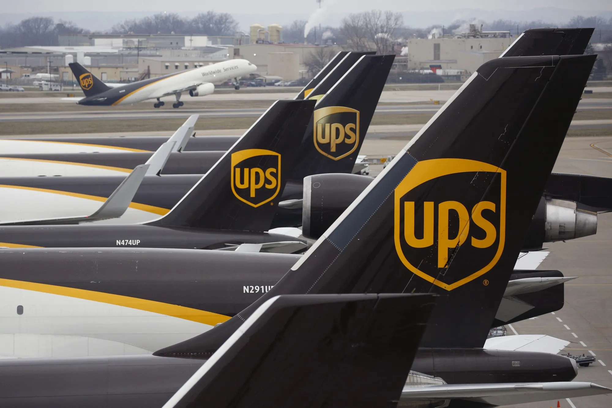 United Parcel Service logos are displayed on the tail of cargo jets parked at a UPS Worldport facility in Louisville, Kentucky.