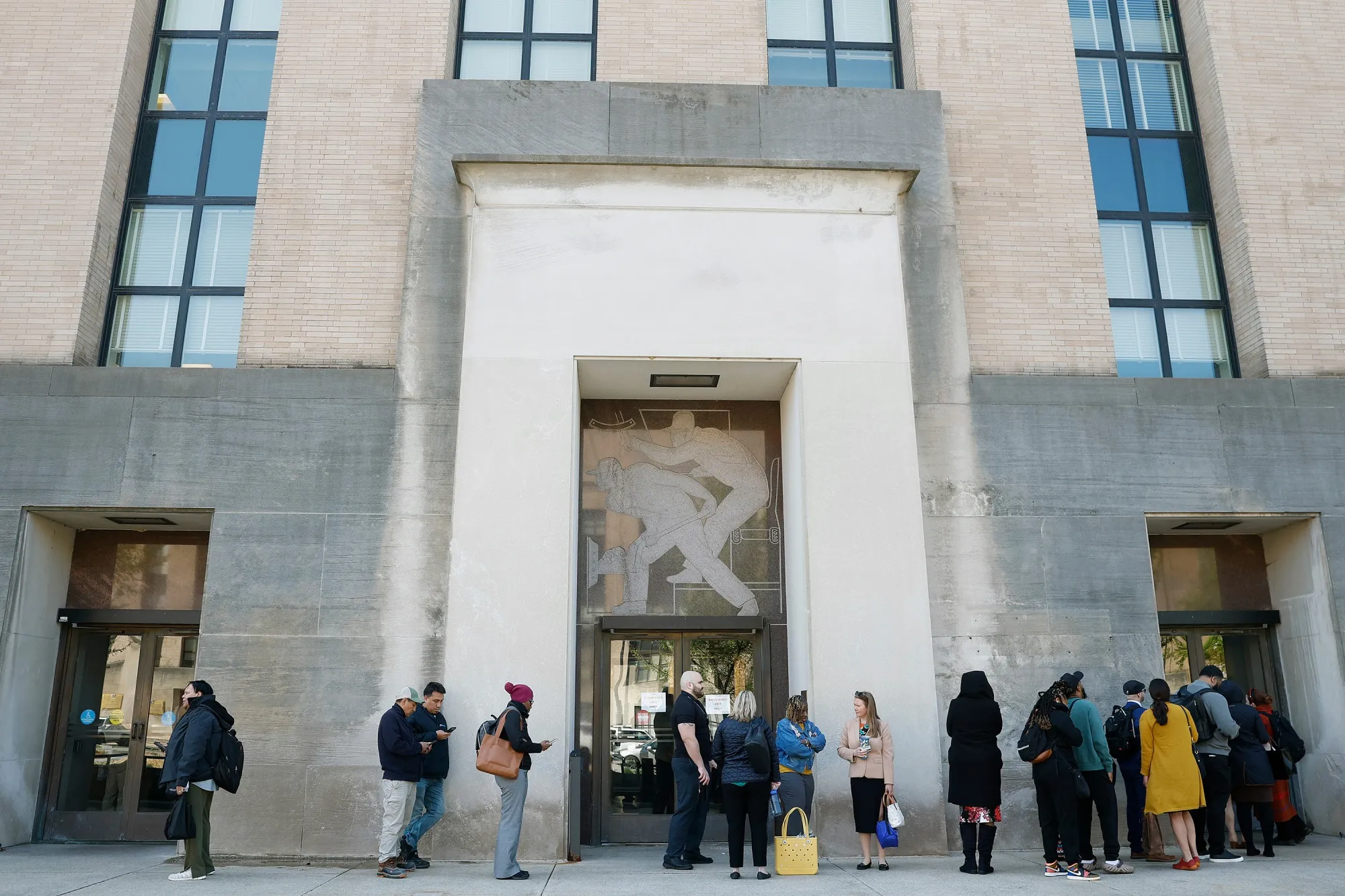 Employees wait to enter the Department of Health and Human Services on April 1.