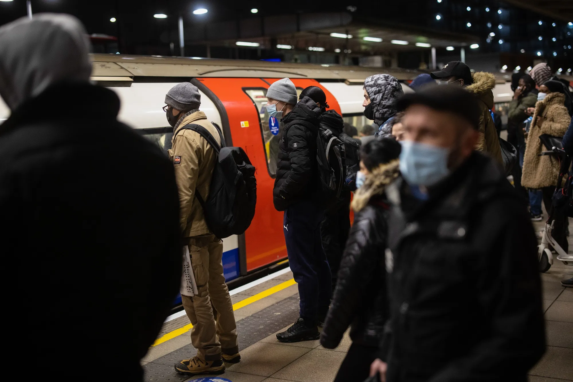 Commuters stand on the Jubilee line platform at Canning Town Station in London.