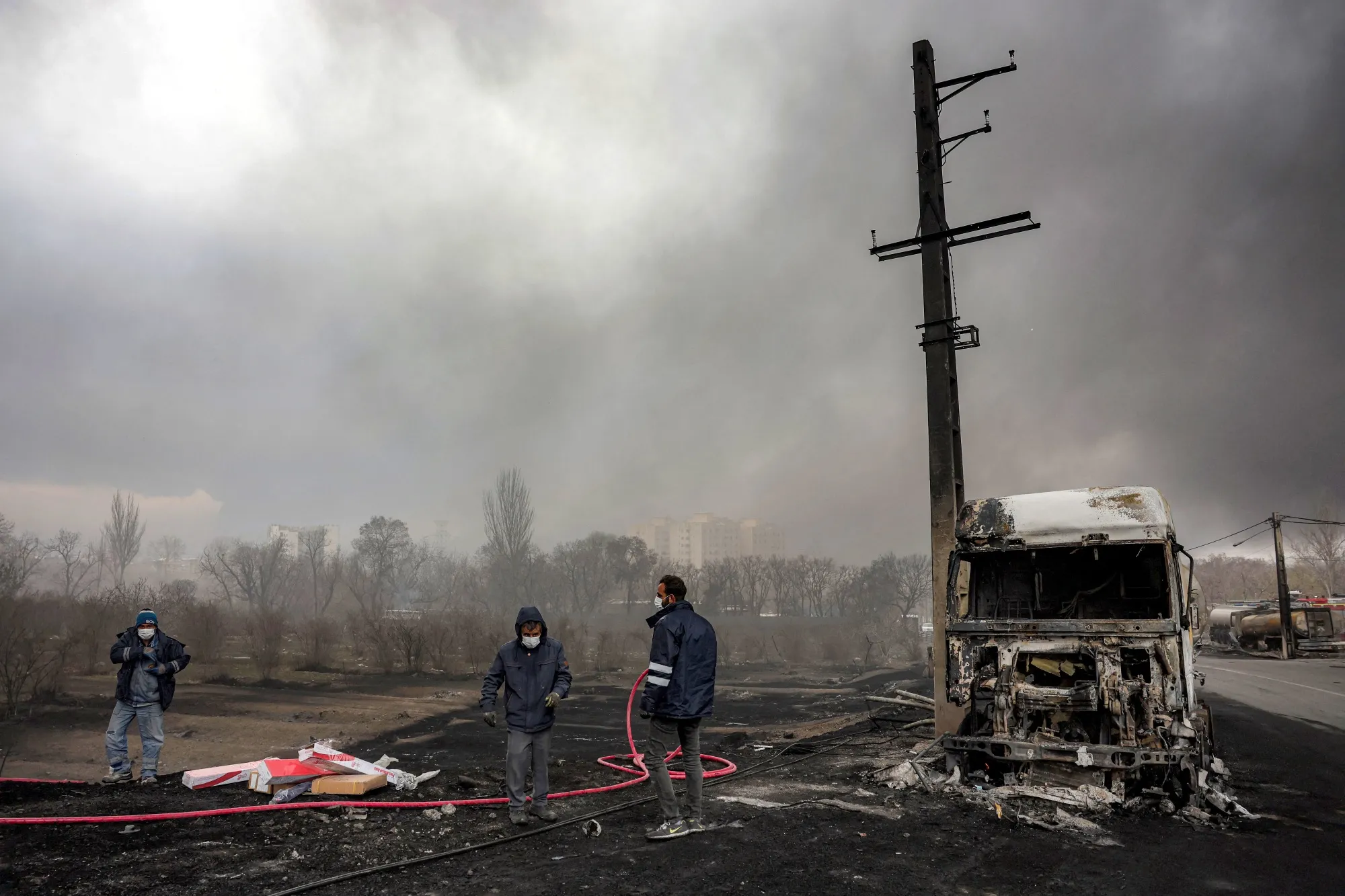 Civil defence members near a destroyed fuel tanker following an overnight airstrike on the Shahran oil refinery, in Tehran, on March 8.