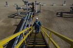 An employee walks down stairs at&nbsp;an oil production facility in Alberta, Canada.