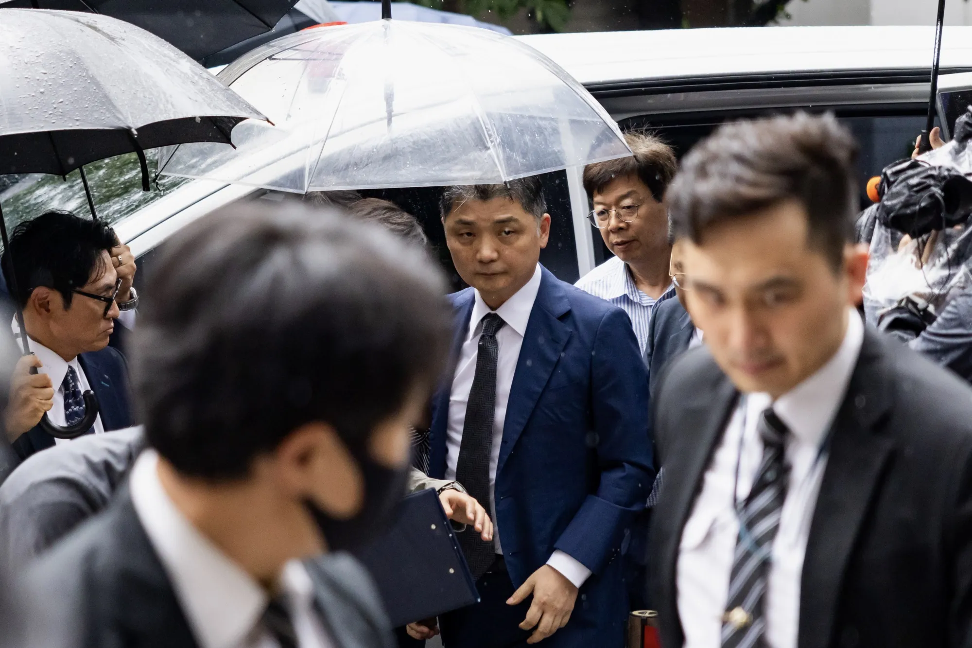 Brian Kim, center, arrives at the Seoul Southern District Court on July 22.