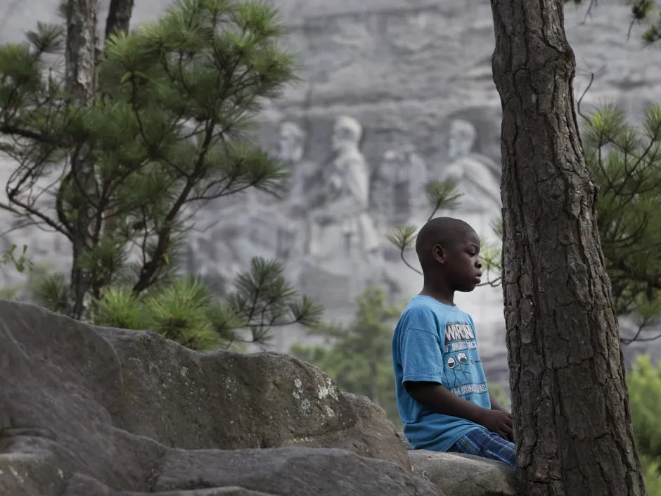 A boy sits in front of Stone Mountain—the Atlanta-area monument to the Confederacy. 