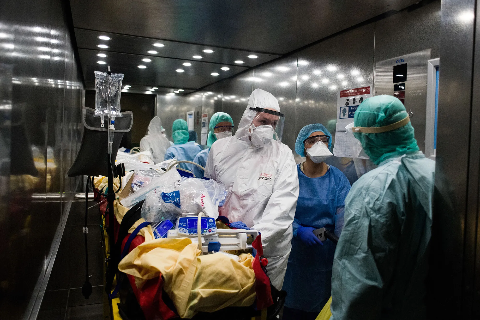 Members of the civil protection ambulance service and medical personnel load a coronavirus patient into an elevator in Paris on April 5.&nbsp;