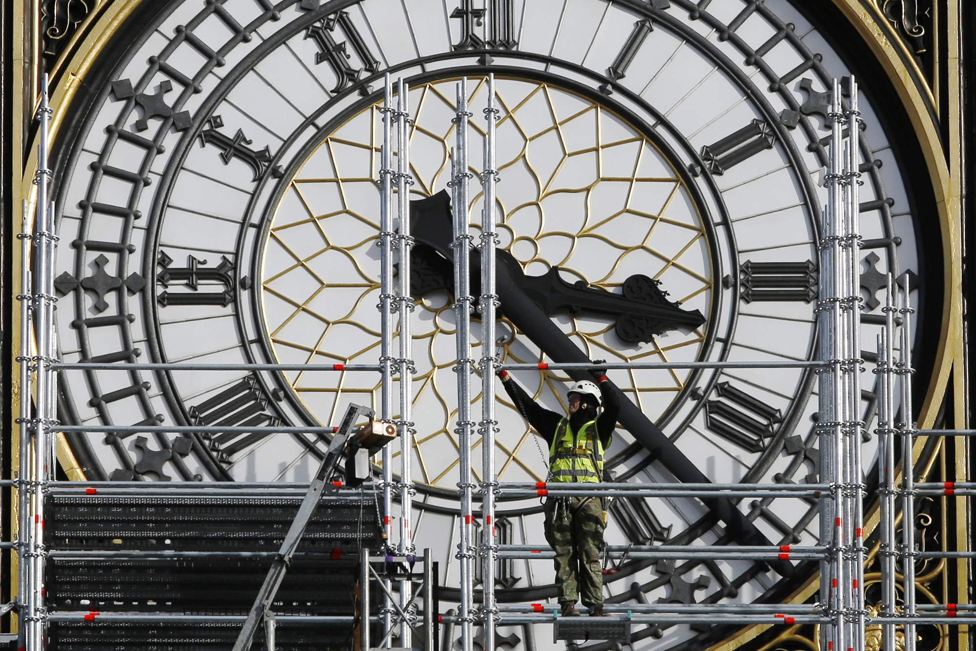 A construction worker adjusts scaffolding outside the clock face on Elizabeth Tower, also known as 'Big Ben', in London, U.K., on Wednesday, Oct. 11, 2017. U.K. Prime Minister Theresa May and her most senior cabinet ministers risk igniting the anger of their Tory colleagues with a series of comments that raise questions over their commitment to Brexit.