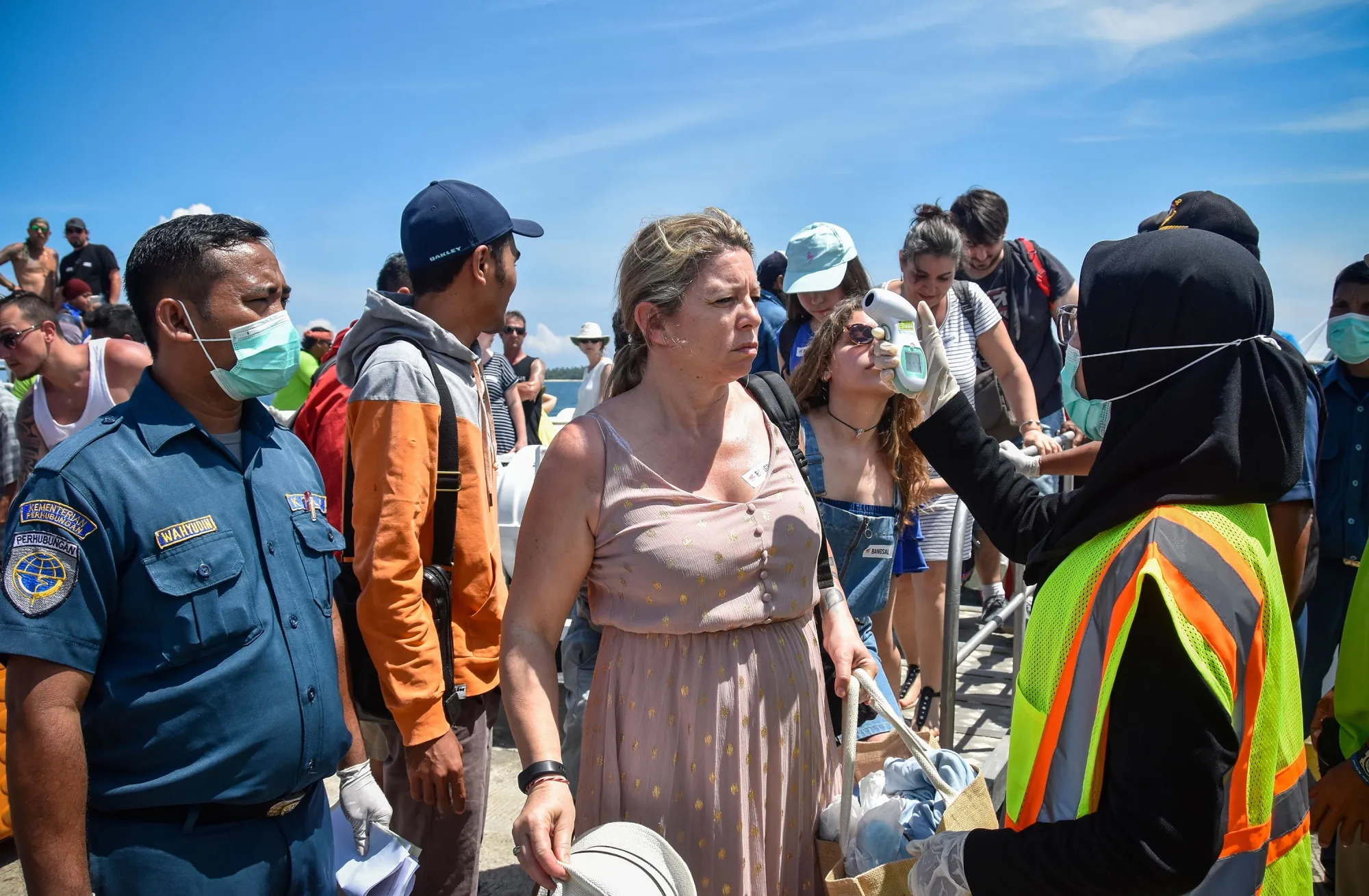 Indonesian health officials check body temperature of&nbsp;tourists arriving from Bali island heading to tourist area Gili Trawangan at the Bangsal port in Pemenang Lombok island on Feb. 12.