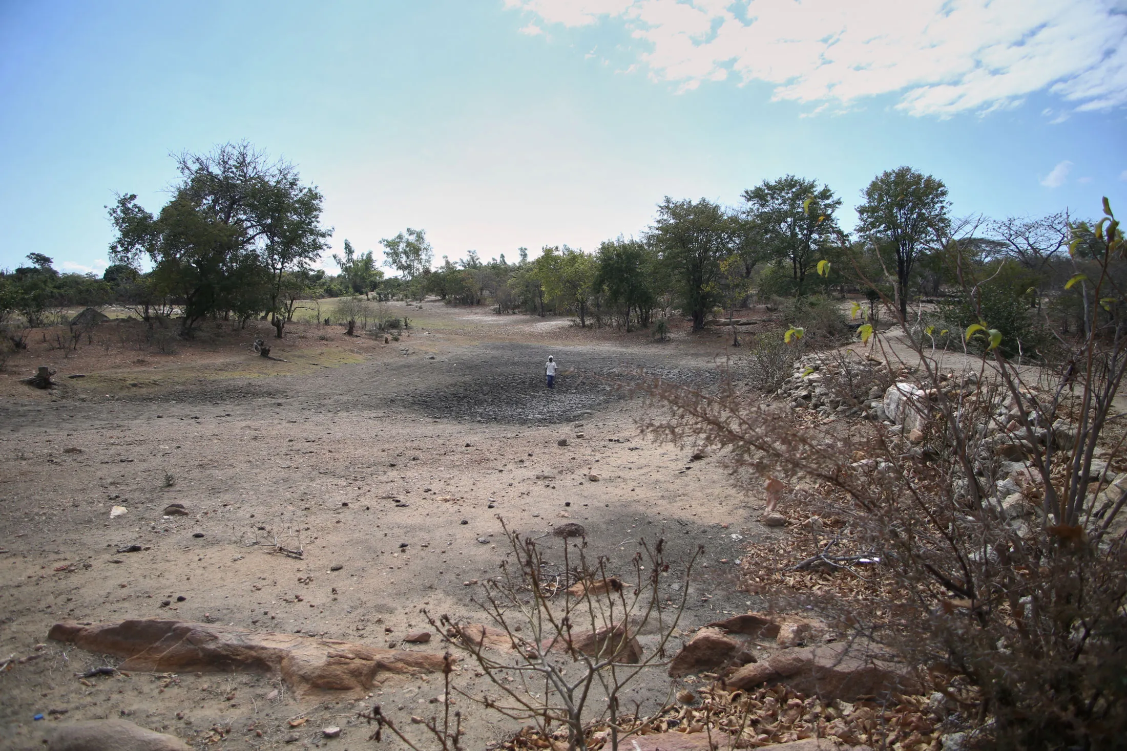 A farmer walks on the dry riverbed at the Kapotesa dam in Zimbabwe in July.