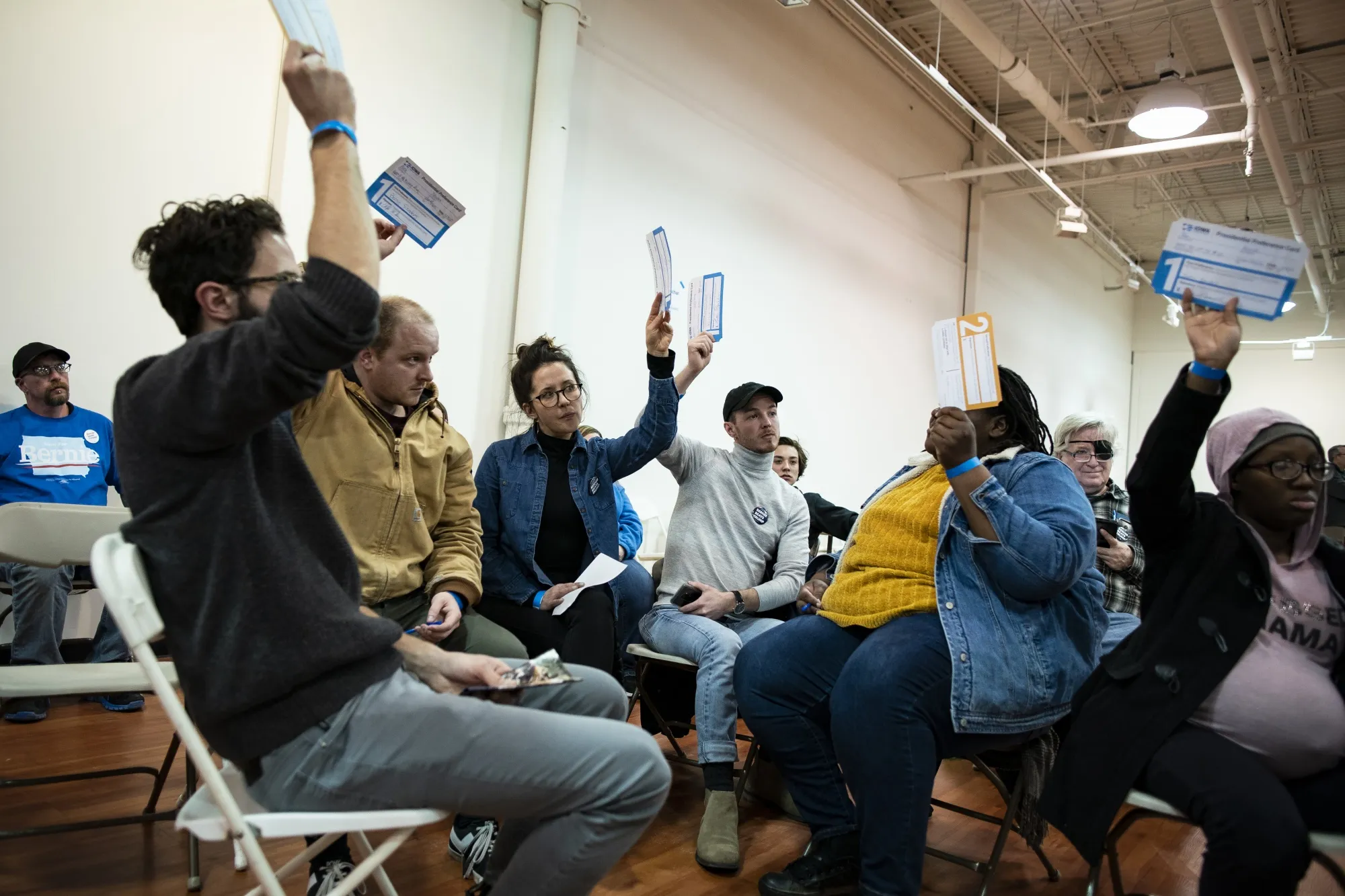 Attendees for Bernie Sanders hold up their Presidential Preference Cards during the first-in-the-nation Iowa caucus at the Southridge Mall in Des Moines on Feb. 3.