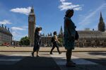 Pedestrians walk through Parliament Square in London, UK.