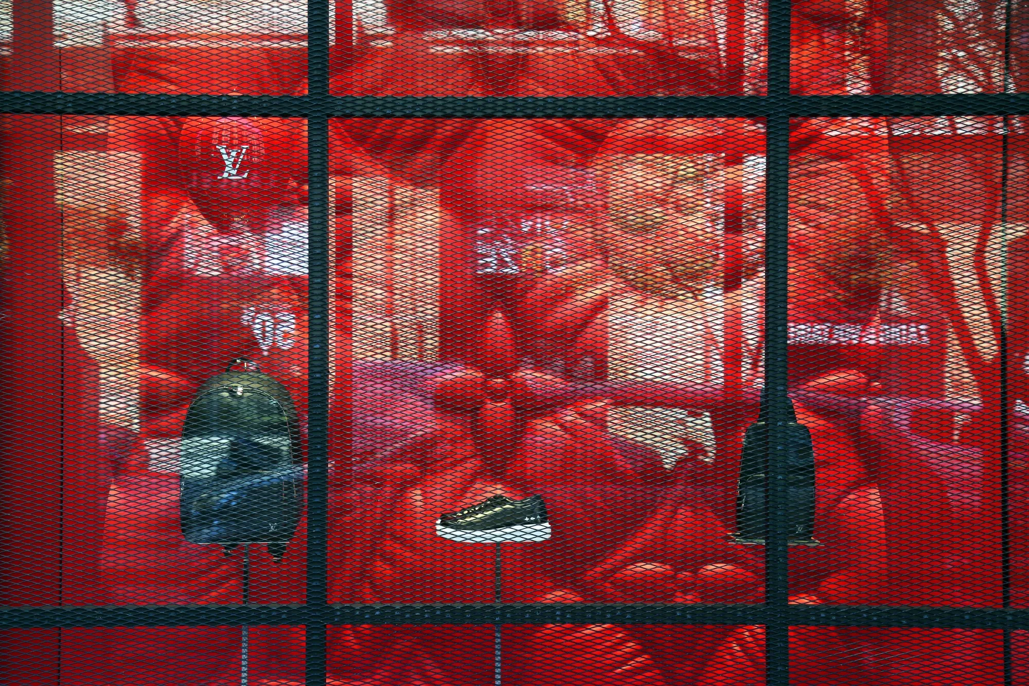 A luxury leather backpack and a sneaker sit behind a protective grille at at Louis Vuitton store in Beirut on March 6.