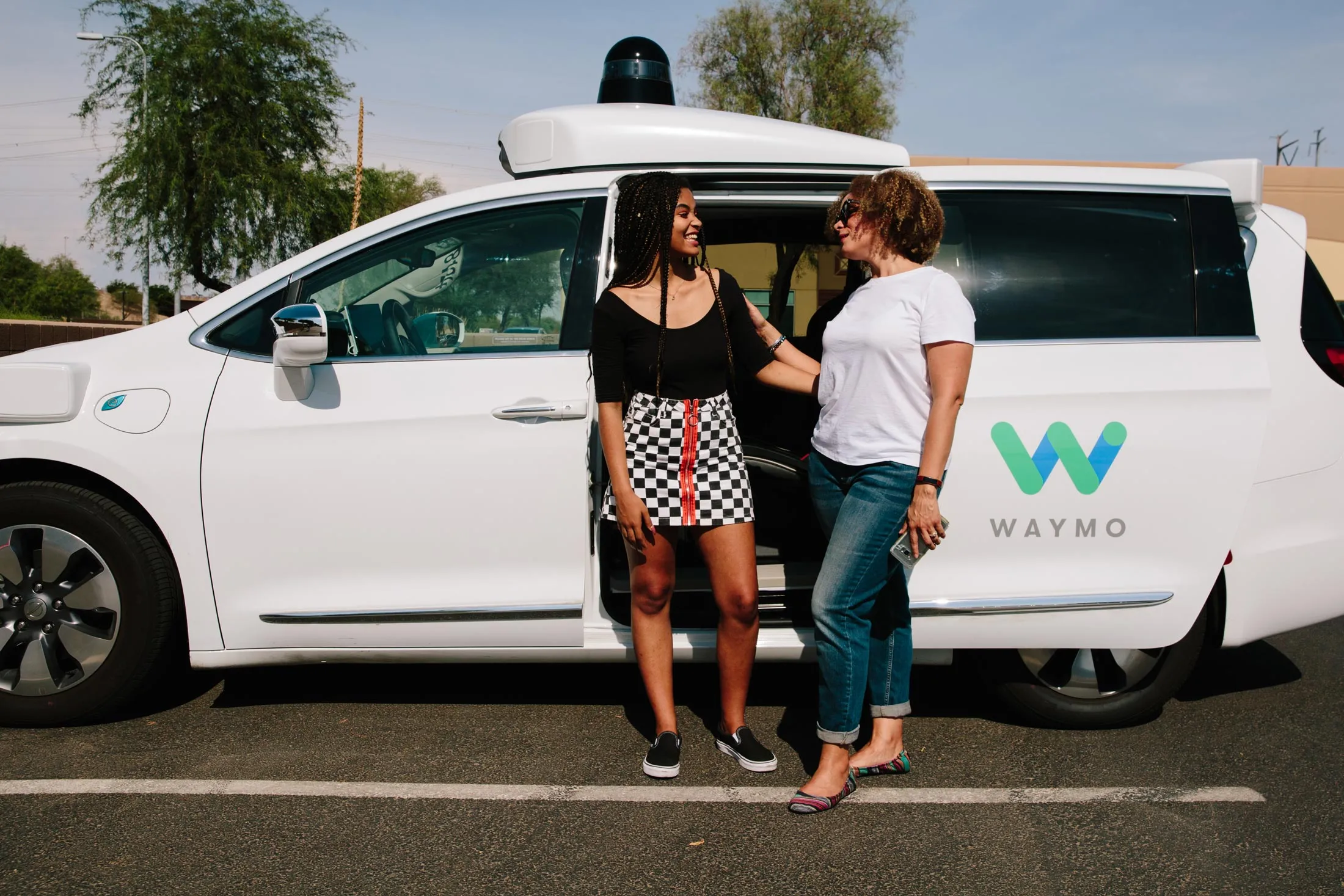 Samantha Jackson, right,&nbsp;and her daughter Kyla, 17,&nbsp;with a Waymo autonomous vehicle. The Jackson family has volunteered to be part of Waymo’s Early Rider program&nbsp;in the Phoenix area.