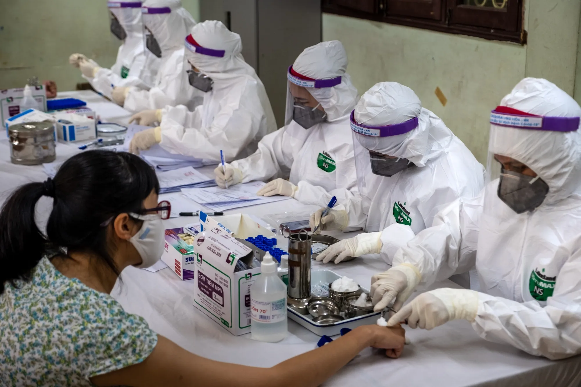 Medical workers perform a rapid Covid-19&nbsp;test on individuals who recently returned from Danang, in Hanoi on July 31.
