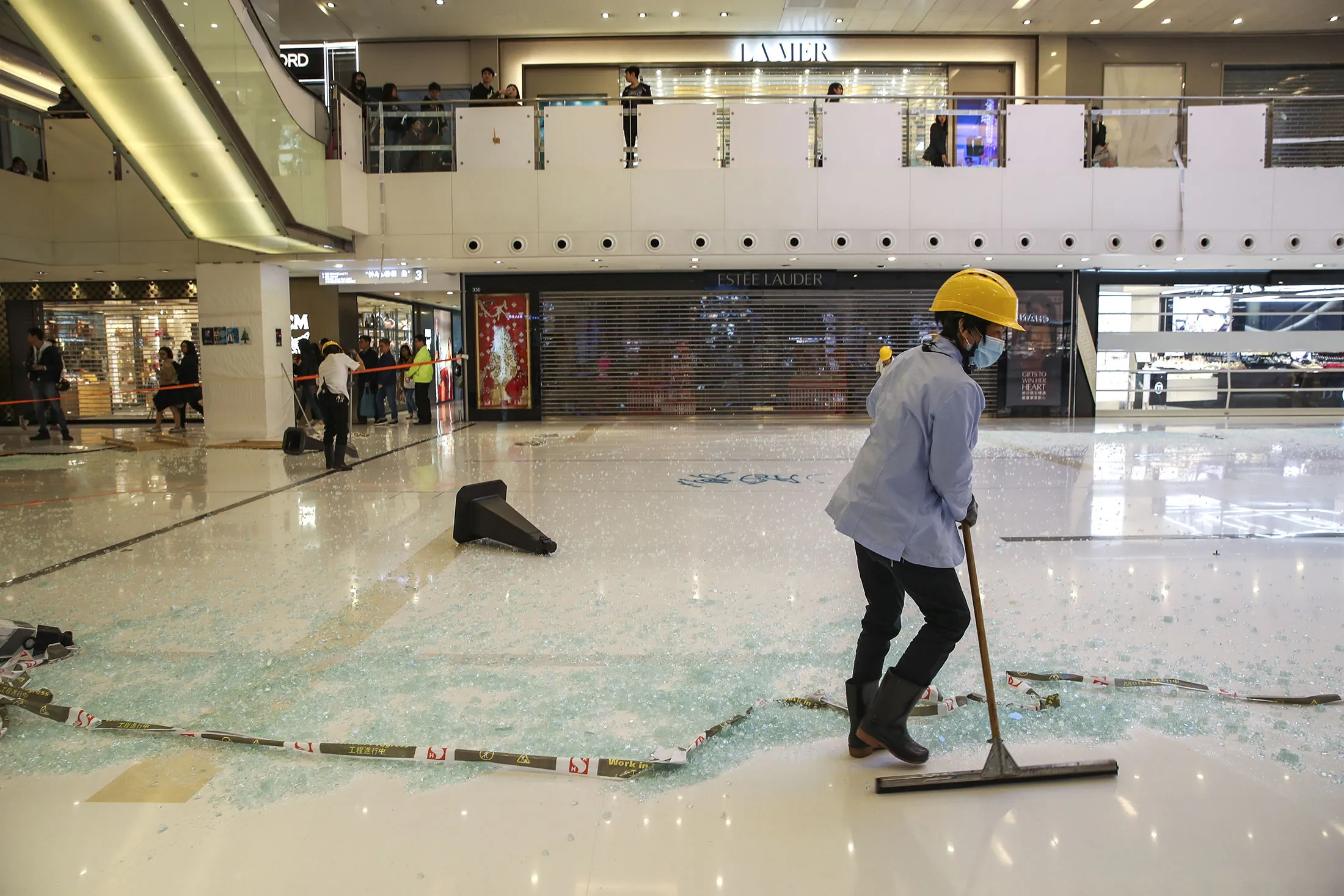 Workers clean up after protests at New Town Plaza in December.