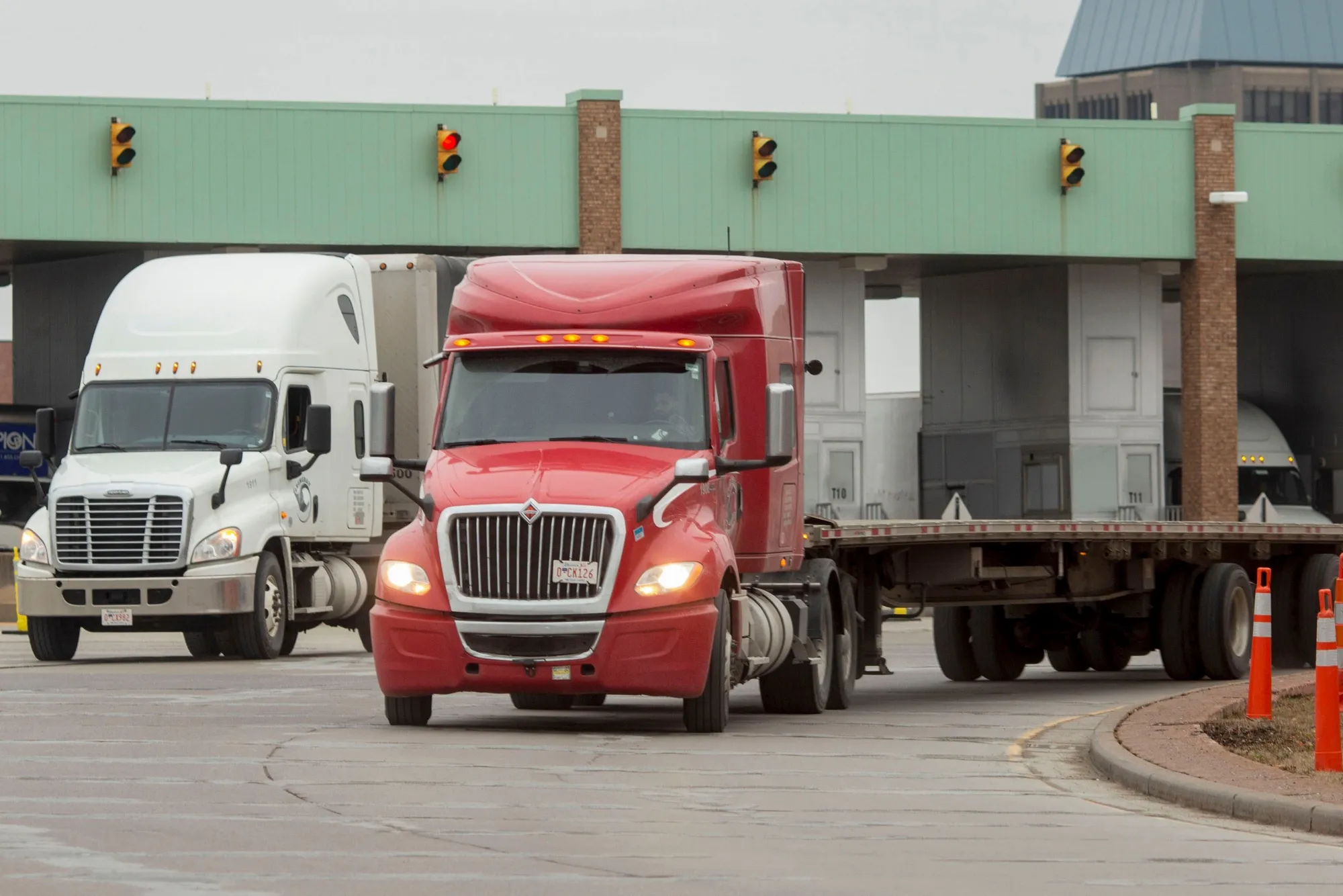Tractor trailers exit Canadian customs after driving across the Ambassador Bridge on the Canada-US border.