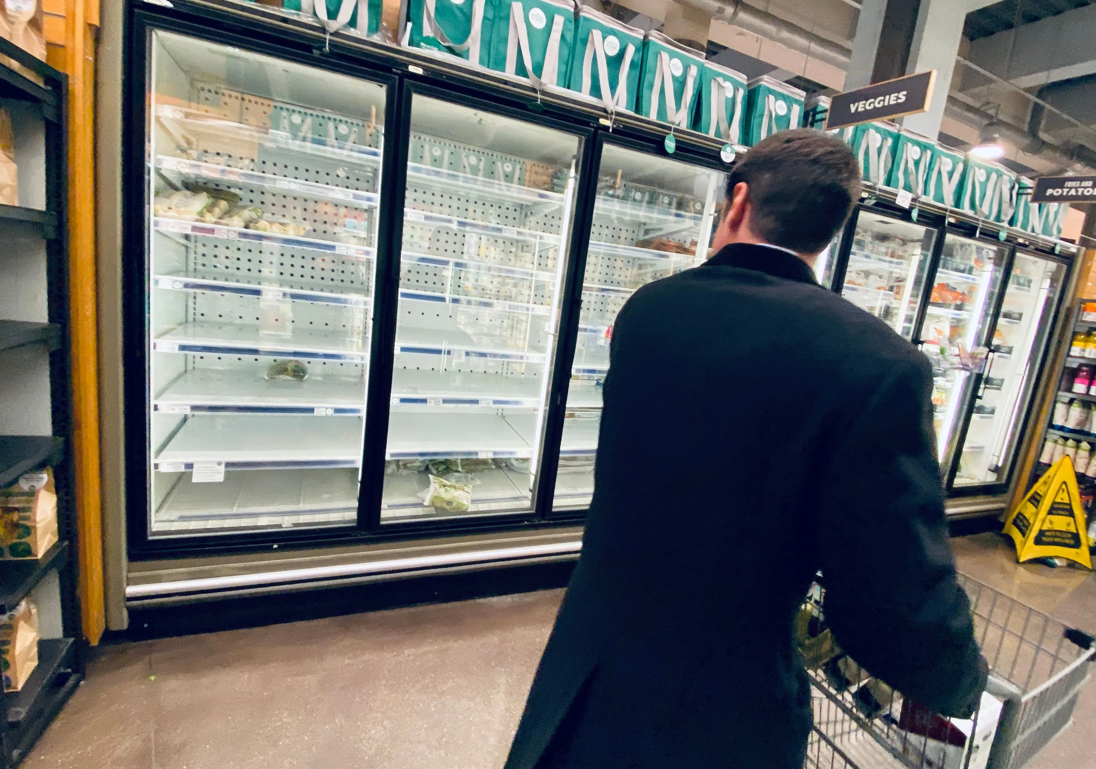 A shopper looks at empty shelves of frozen food in a supermarket in Washington, D.C., on March 11, 2020.
