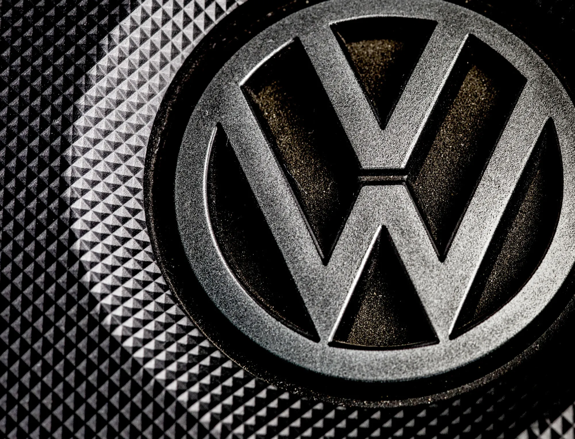 A VW logo sits on a covering under the bonnet of a Volkswagen AG Passat TDI automobile powered by a turbocharged direct injection engine in London, U.K., on Wednesday, Dec. 2, 2015. Volkswagen is grappling with an emissions scandal on three fronts: cheating software installed in about 11 million vehicles worldwide with 1.2-, 1.6- and 2.0-liter engines; irregular carbon dioxide ratings on about 800,000 vehicles in Europe; and questionable emissions software in about 85,000 VW, Audi and Porsche vehicles with 3.0-liter diesel engines in the U.S.
