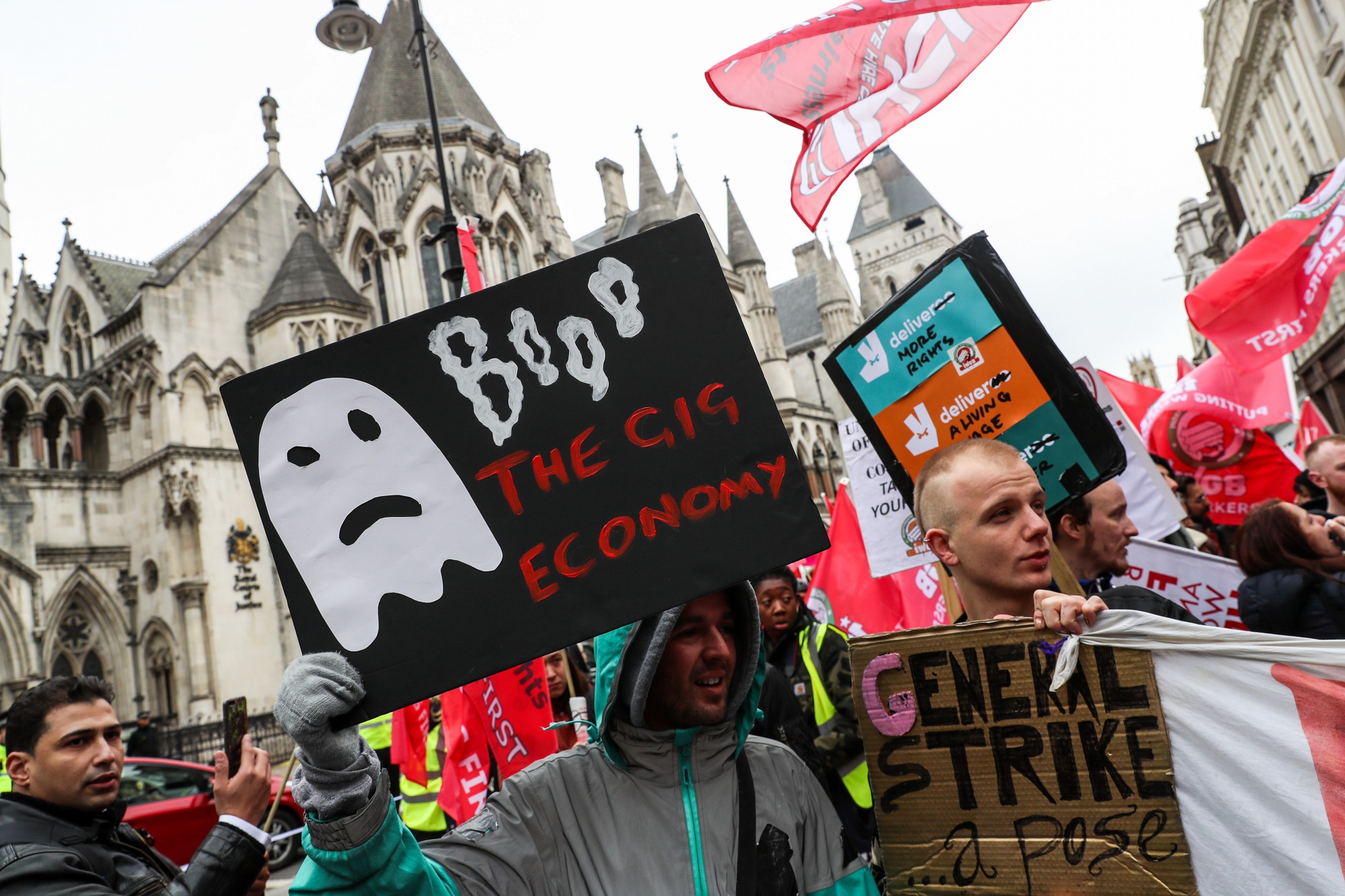 A demonstrator holds by a sign that says "Booo The Gig Economy" during a march, supporting gig-economy workers, to the Court of Appeal in London, U.K., on Tuesday, Oct. 30, 2018. James Farrar and Yaseen Aslam, Uber&nbsp;drivers spearheading an employment lawsuit, say they should be classed as the company's "workers," meaning they’re entitled to the minimum wage and vacation pay.