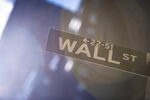 A Wall Street sign is displayed in front of New York Stock Exchange.