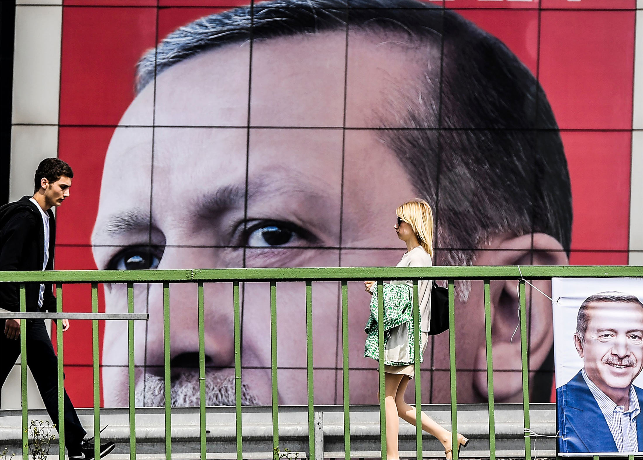 People walk in front of a&nbsp;poster of Turkish President Recet Tayyip Erdogan&nbsp;in Istanbul on April 6, 2017.