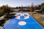 A basketball court in Pacoima with solar reflective coating applied in Dodger blue.