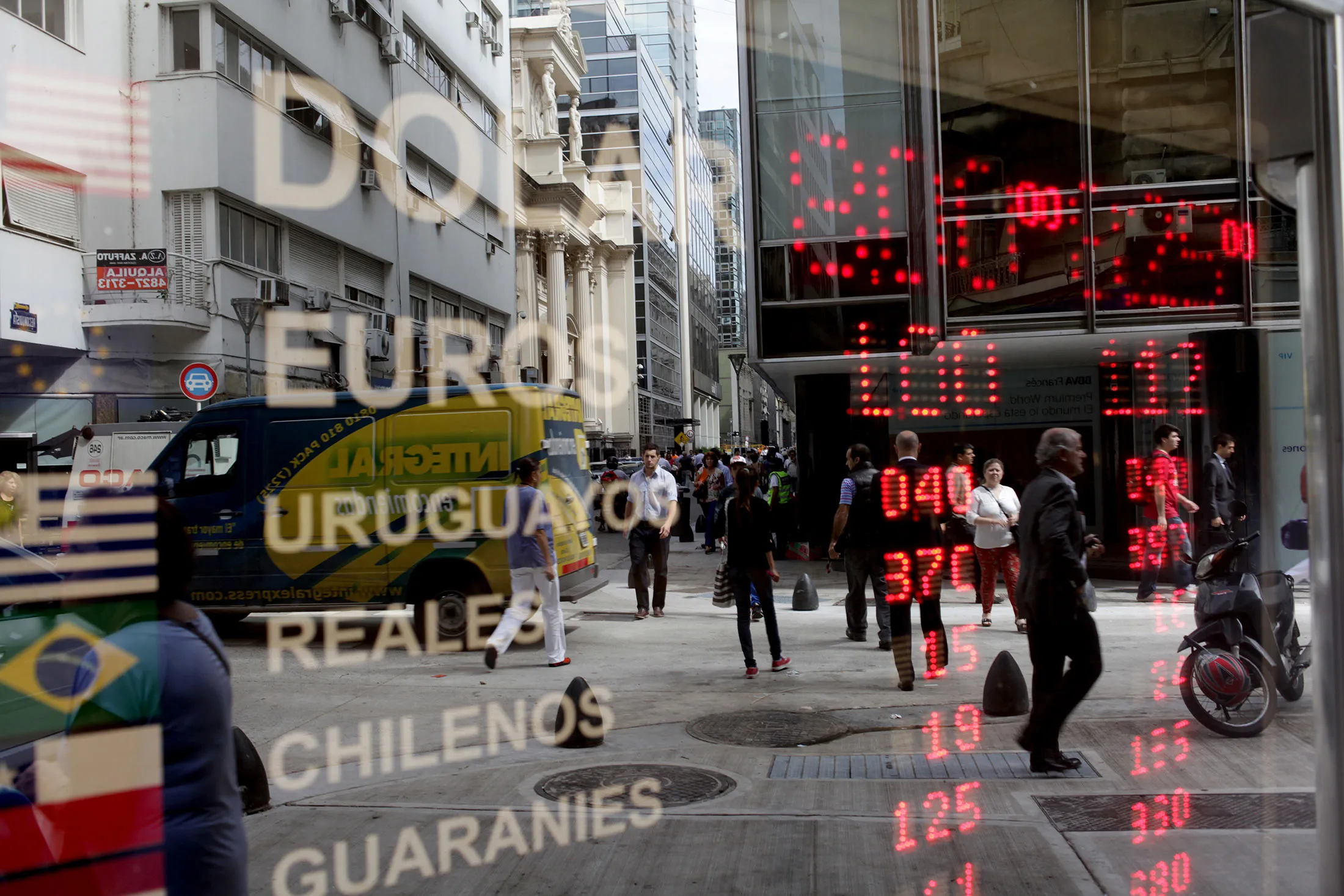 Currency exchange rates are reflected in a window in Buenos Aires, Argentina, on Feb. 12, 2014.
