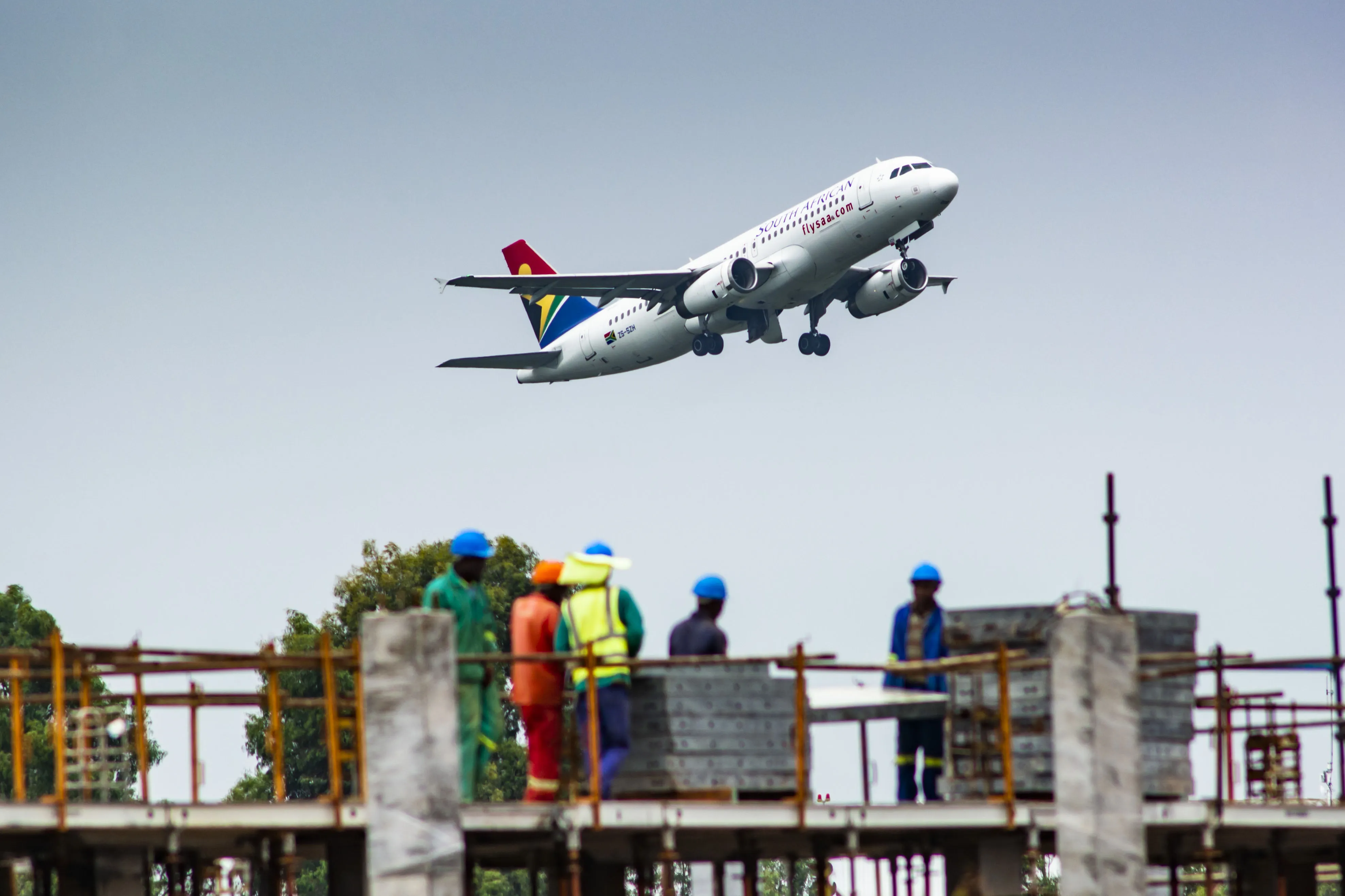 An Airbus A320-200 passenger jet, operated by South African Airlines, flies above a construction site&nbsp;in Johannesburg.