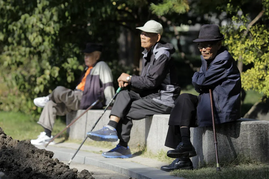 Elderly men sit on benches at Tapgol Park in the Jongro-gu area of Seoul, South Korea.
